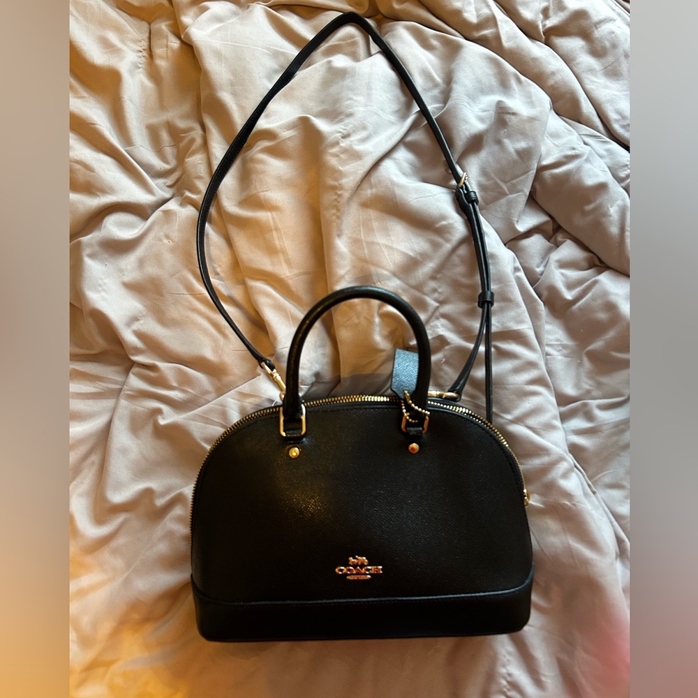 Black coach purse with cross body strap.